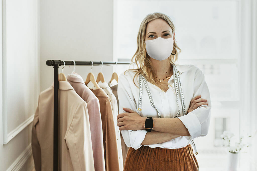 Designer in new normal boutique wearing mask, covid 19